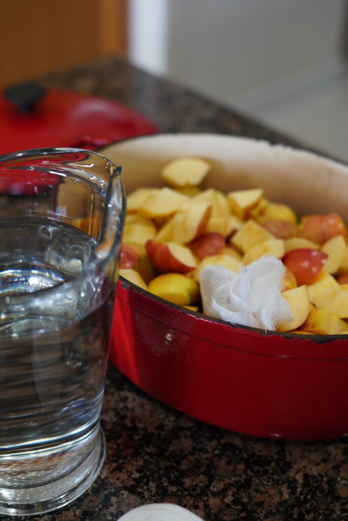 Chopped apples in pot with spice bundle