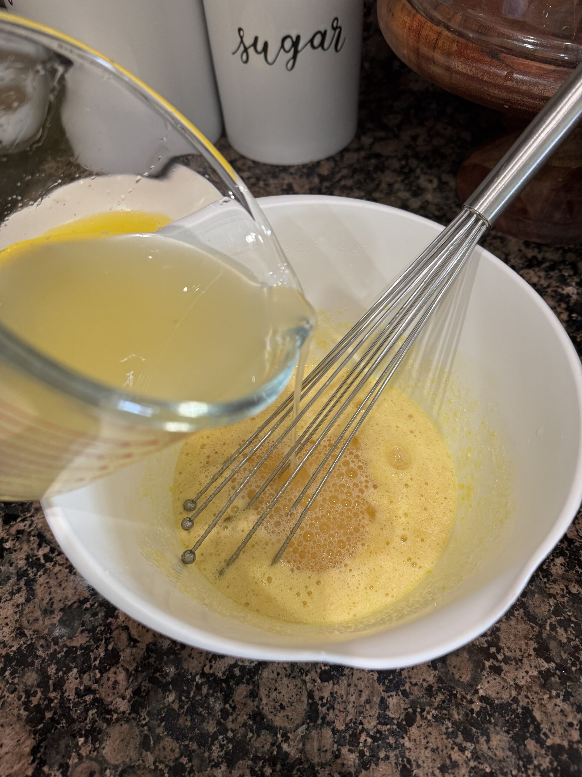 Adding fresh lemon juice to egg and sugar in bowl