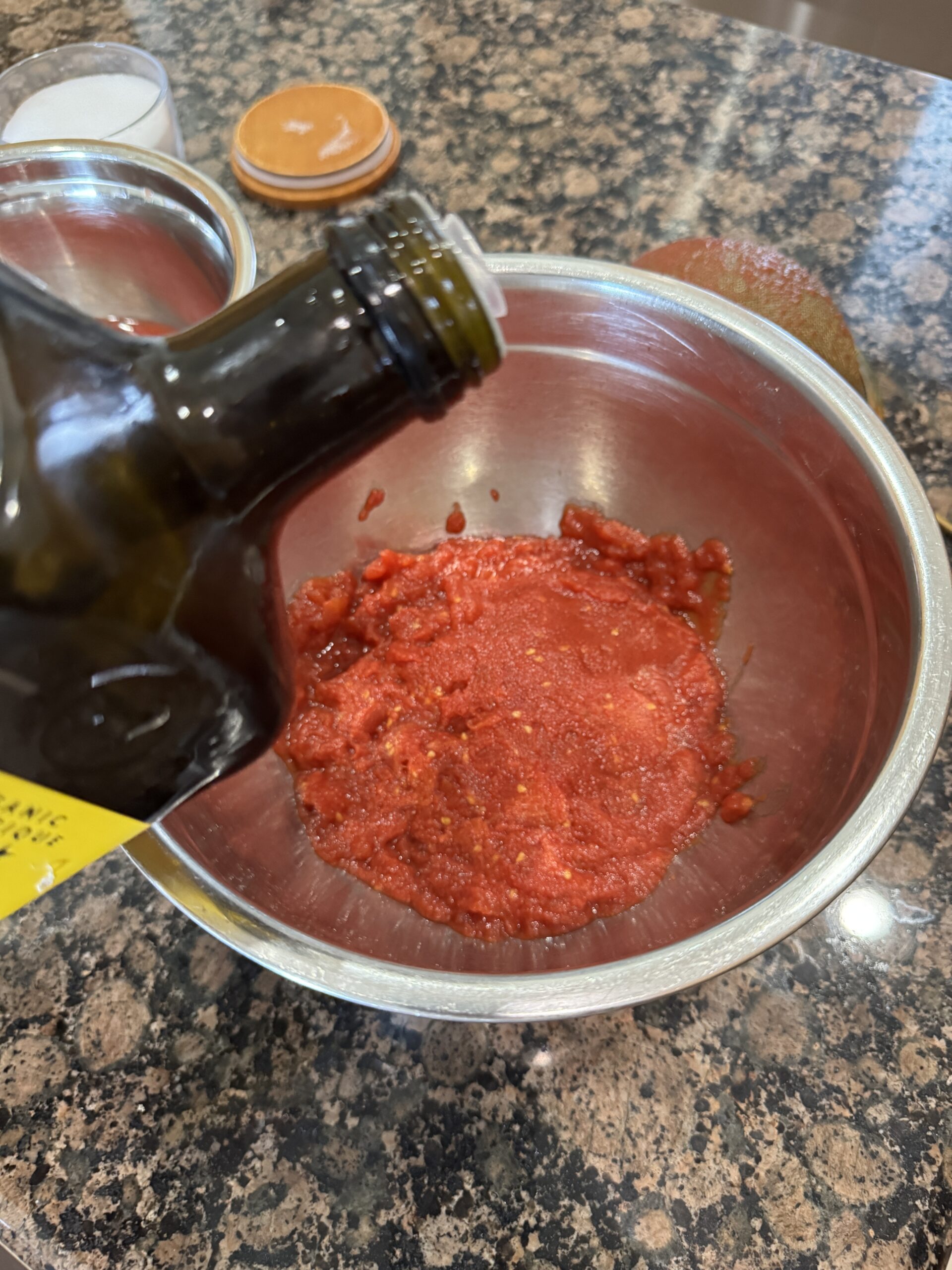 Adding olive oil into crushed canned tomatoes