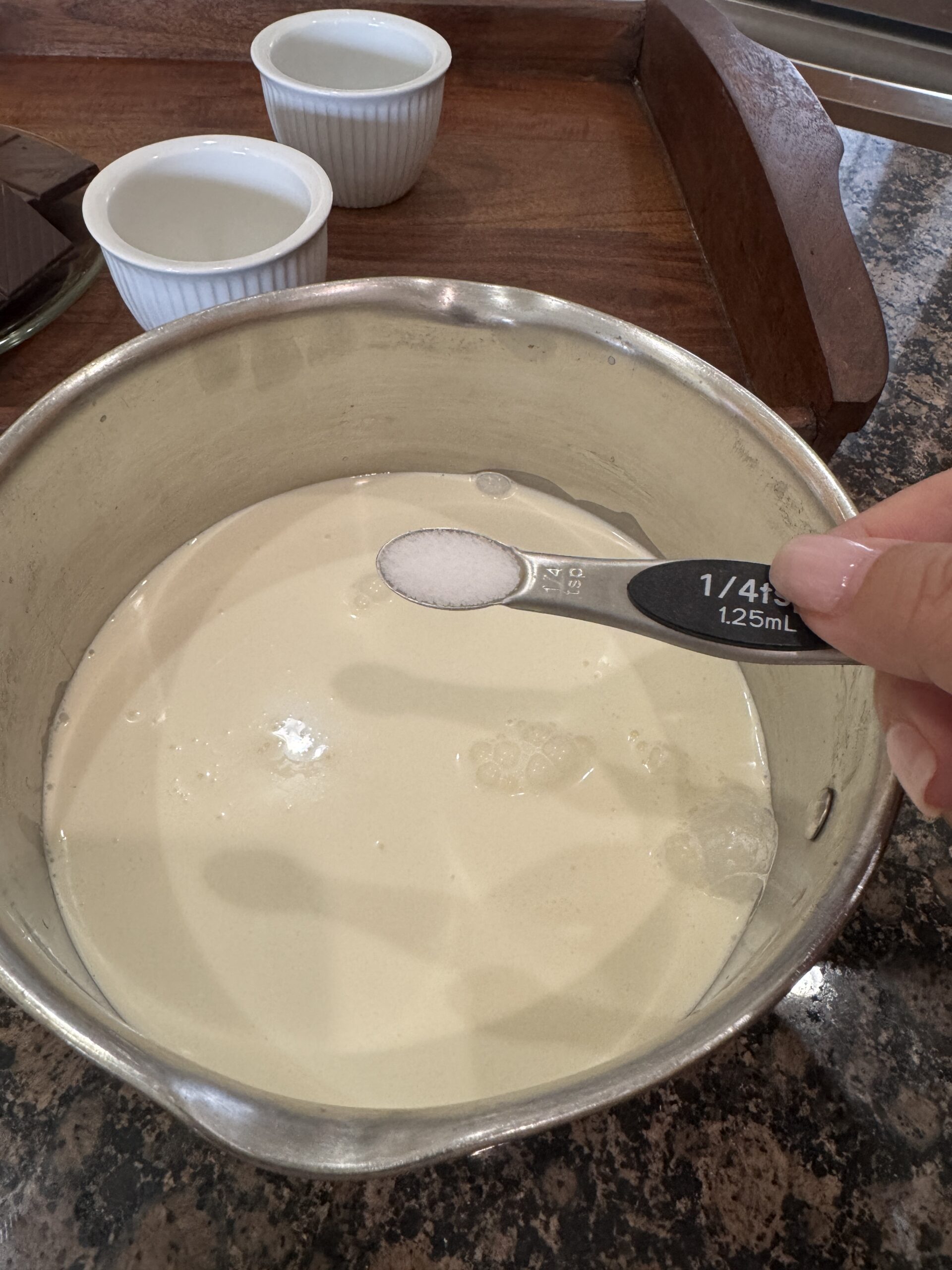 Adding salt to milk and cream in sauce pan